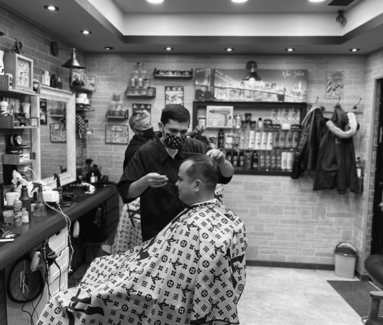 Barber working with a client inside Big Tony's Barbershop