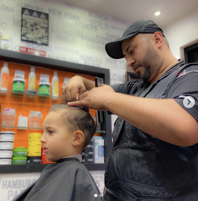 Barber carefully cutting a young child's hair